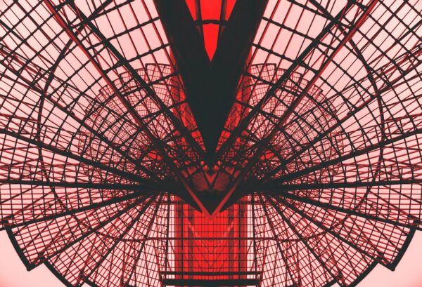 Abstract view of a red geometric architectural structure, showcasing modern design and symmetry.