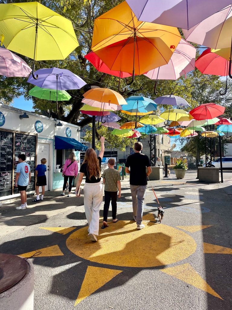 Kids Walking Under Bright Umbrellas In Cash Alley In Ocean Springs Mississippi