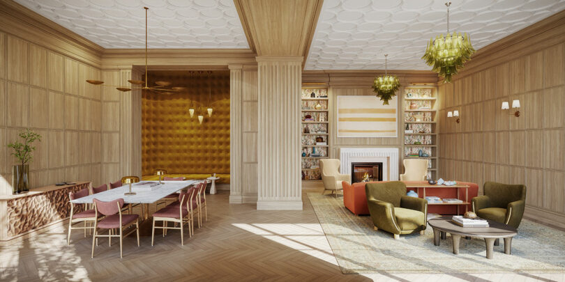 Luxurious dining and living area designed by Elizabeth Graziolo, featuring a long dining table, plush seating, gold-accented walls, a modern chandelier, and a fireplace with bookshelves on either side.