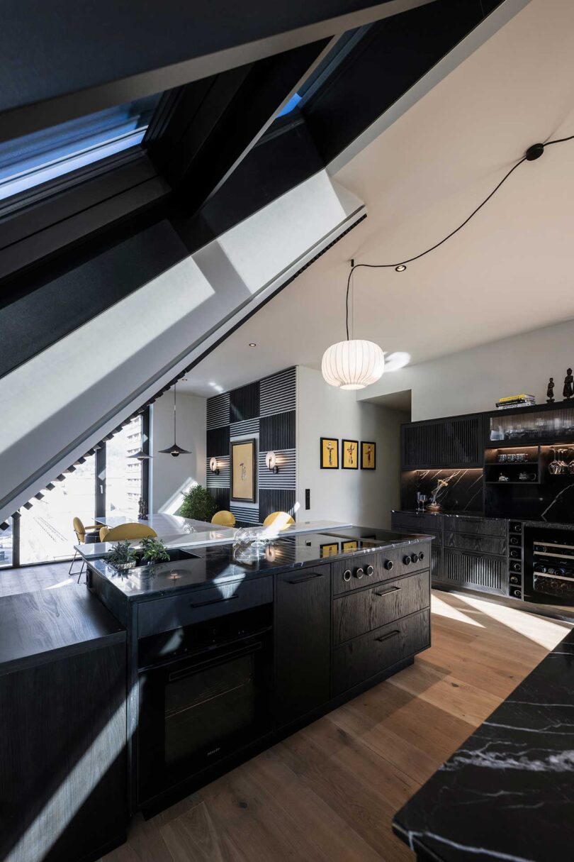 modern apartment interior with slanted glass walls with black kitchen islands